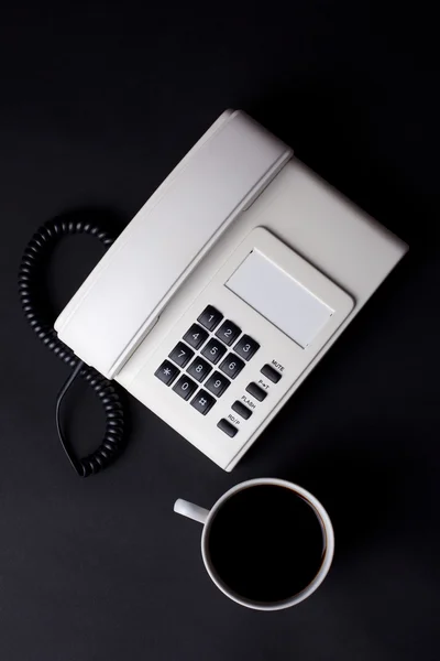 Koffie beker en witte telefoon — Stockfoto