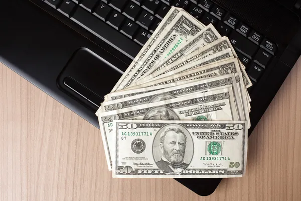 Dollar sedlar på laptop tangentbord — Stockfoto