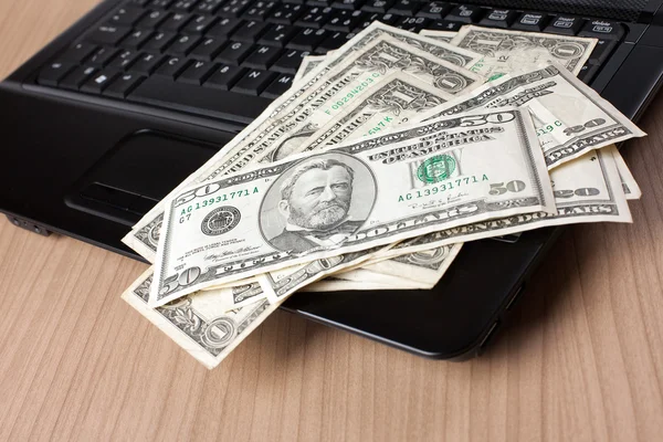 Dollar banknotes on laptop keyboard — Stock Photo, Image