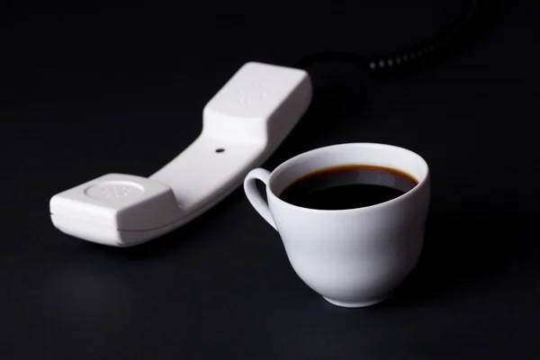 Koffie beker en telefoon ontvanger — Stockfoto