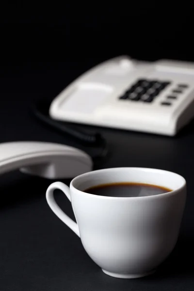 Coffee cup and white telephone — Stock Photo, Image