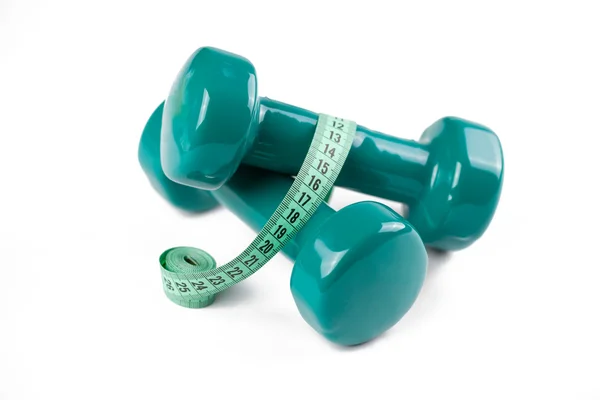 Green dumbell with measuring tape — Stock Photo, Image