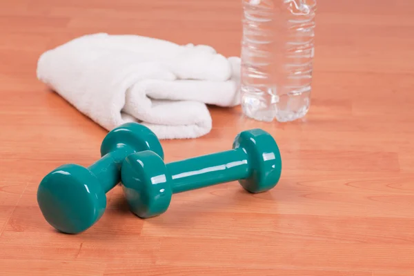 Green dumbells with towel — Stock Photo, Image