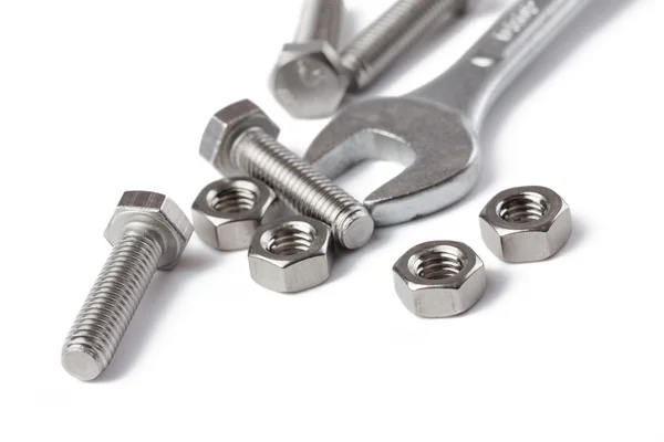Chrome spanner with nuts and bolts — Stock Photo, Image