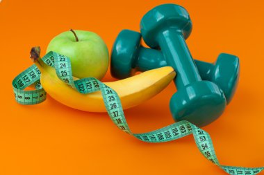 Dumbells with measuring tape and fruits clipart