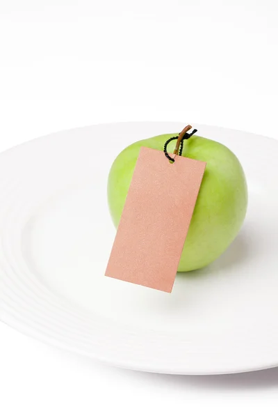 Green apple with label — Stock Photo, Image