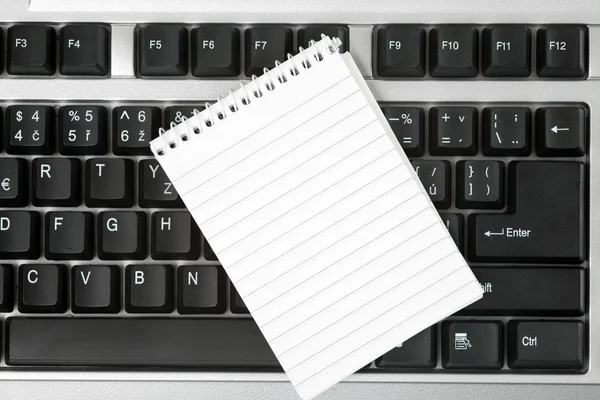 Cuaderno en blanco en el teclado — Foto de Stock