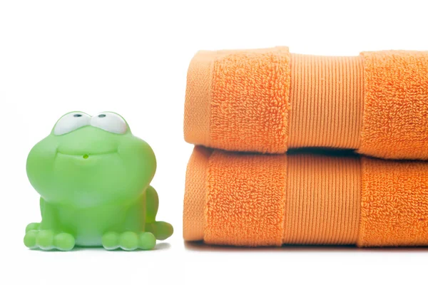 オレンジ色のタオル、おもちゃのカエル — ストック写真