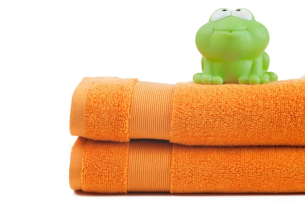 Pomarańczowy ręczniki i zabawki żaba — Zdjęcie stockowe
