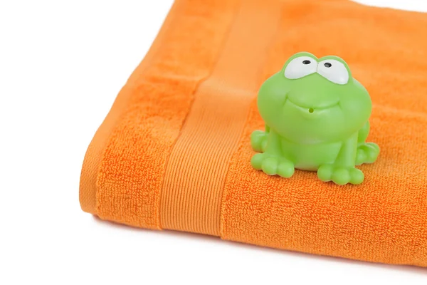 Orange towel and toy frog — Stock Photo, Image