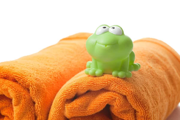 オレンジ色のタオル、おもちゃのカエル — ストック写真