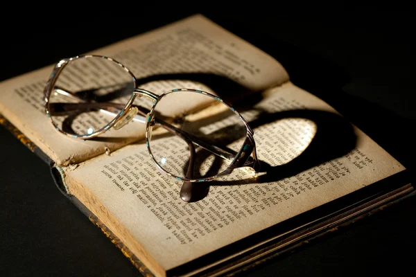 Oud boek met bril — Stockfoto