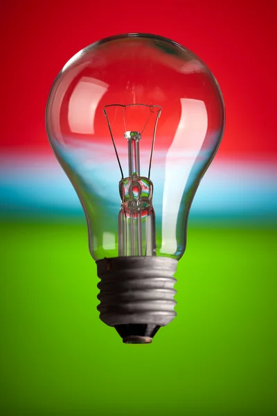 Žárovka na barevném pozadí — Stock fotografie