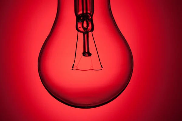 Žárovka na červeném pozadí — Stock fotografie