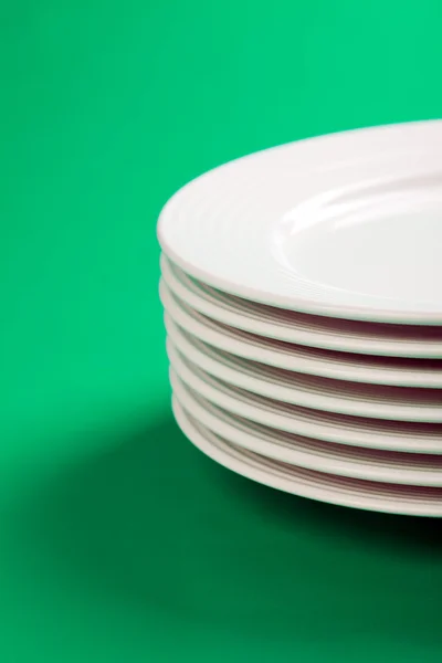Біла тарілка на зеленому фоні — стокове фото