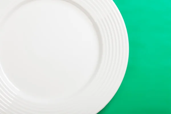 Yeşil zemin üzerine beyaz tabak — Stok fotoğraf