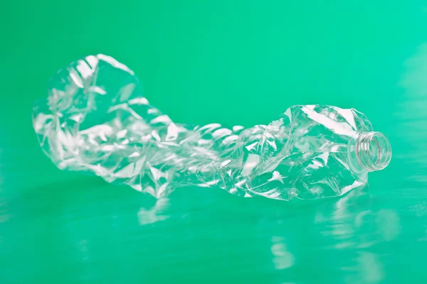 Пластиковая бутылка на зеленом фоне — стоковое фото