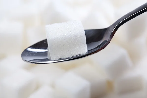 Sugar cube on spoon — Stock Photo, Image