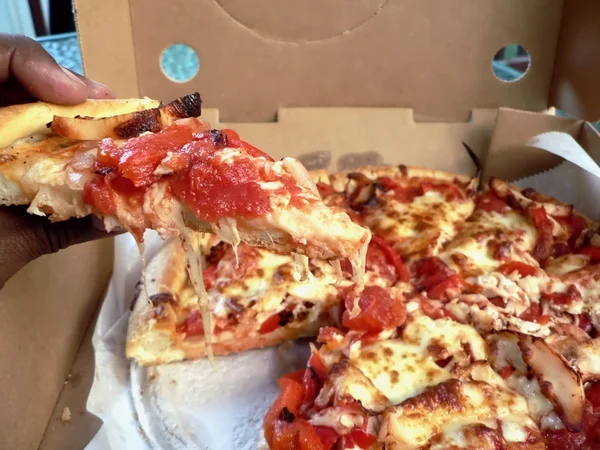 Pizza - dilimi tutan elini — Stok fotoğraf