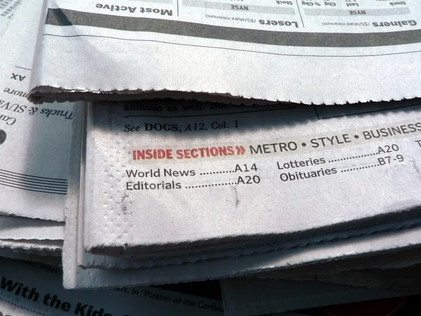 Newspaper stacked up and displaying what's featured inside — Stock Photo, Image