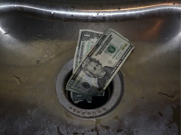 Деньги в канализацию — стоковое фото