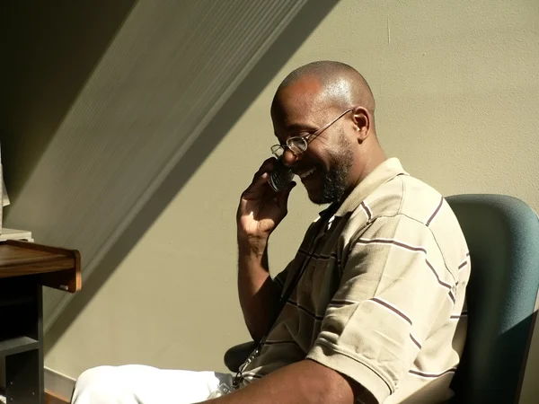 Człowiek rozmowy na telefon komórkowy w cieniu — Zdjęcie stockowe