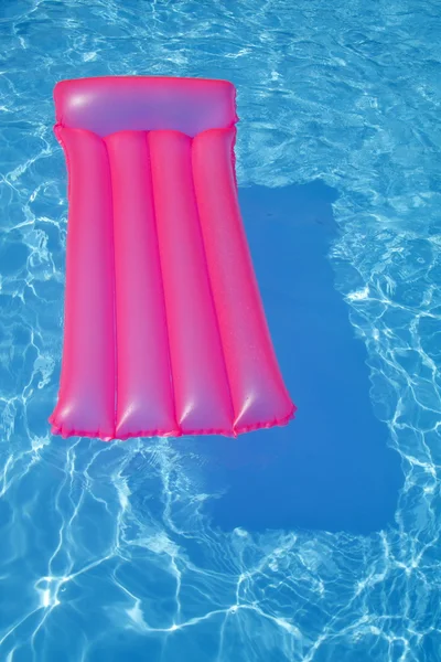 Pink air bed in a pool