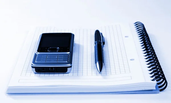 Caneta de telefone móvel e bloco de notas em espiral — Fotografia de Stock
