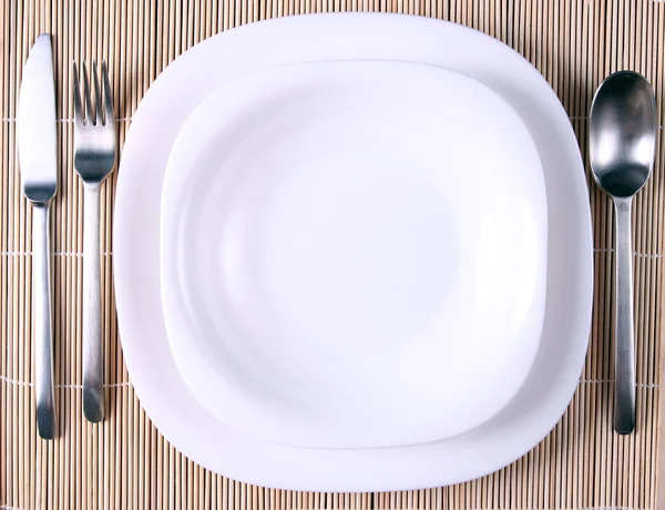 Un plato blanco con utensilios —  Fotos de Stock