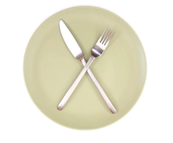 Πηρούνι και μαχαίρι στο πράσινο πιάτο — Φωτογραφία Αρχείου