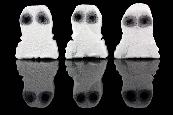 Три белых призрака на черном фоне — стоковое фото