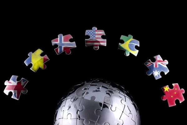 Jigsaw flags around a chrome globe — Stock Photo, Image
