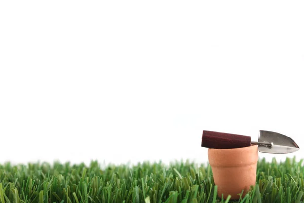 Pflanzkübel mit Kelle auf Gras — Stockfoto