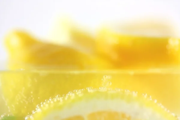Fresh lemons in water with bubbles — Stock Photo, Image