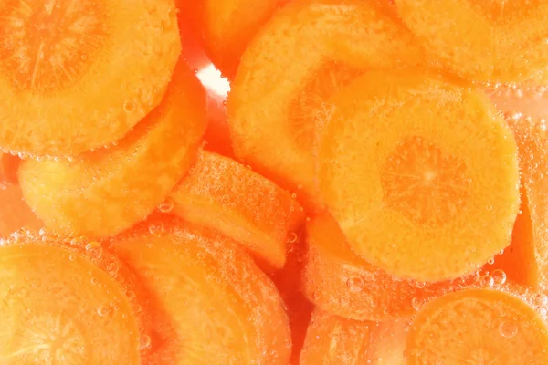 Chopped fresh carrots in water — Stock Photo, Image