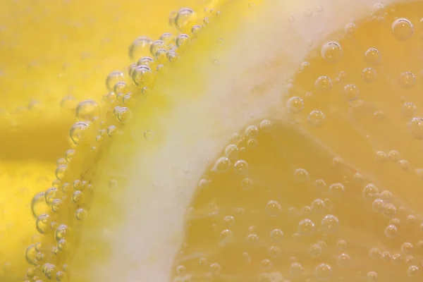 Sliced lemon in refreshing fizzy water — Stock Photo, Image