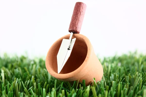 Plant pot with trowel on grass — Stock Photo, Image