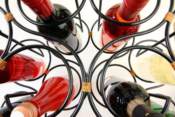 Butelek wina w zakrzywione stojak na wino — Zdjęcie stockowe