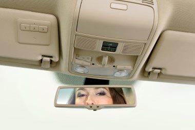 Woman looks on the rear-view mirror clipart
