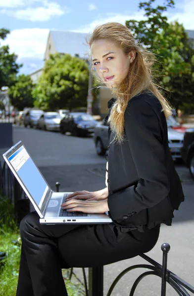 Glad affärskvinna med bärbar dator — Stockfoto