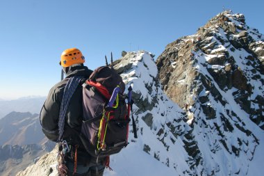 Climber on sharp mountain ridge clipart