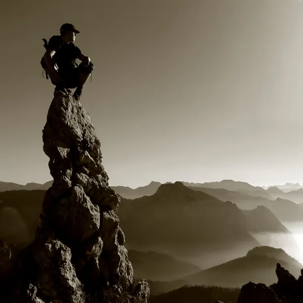 Bergslandskapet - man på toppen av en klippa Stockfoto