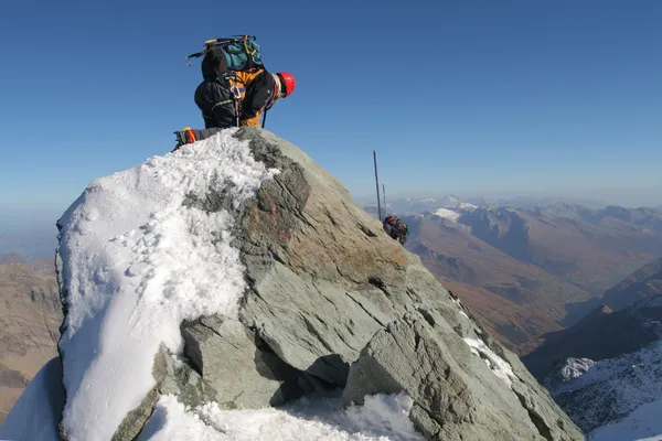 Climber climbing mountain ridge — Stock Photo, Image