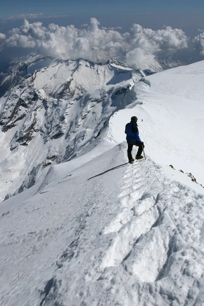 Climber climbing snow ridge. — Stock Photo, Image