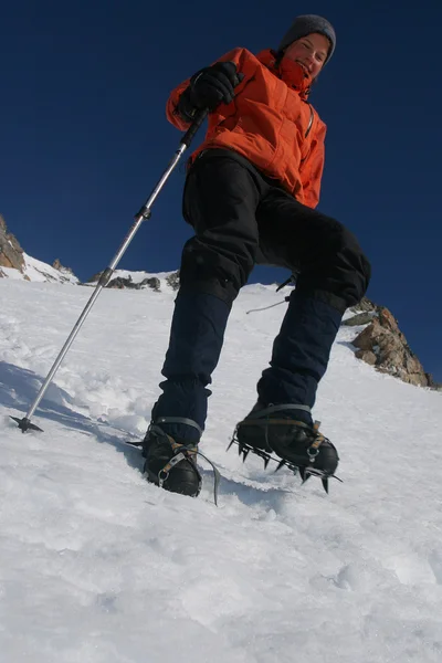 Альпинист с костылями на леднике — стоковое фото