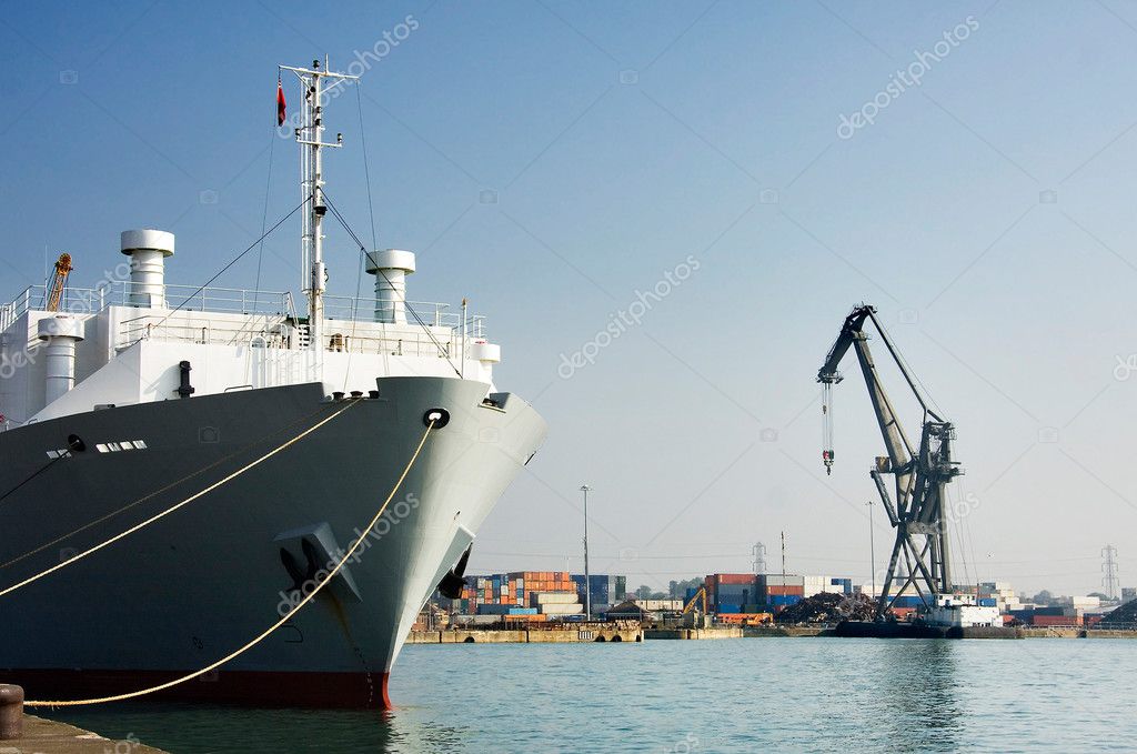 Ship in port, Southampton, UK. Crane and containers on dockside - all logos removed or obscured.