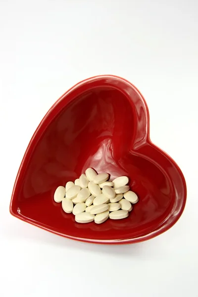 Ilaçlar ve parlak kırmızı kalp — Stok fotoğraf