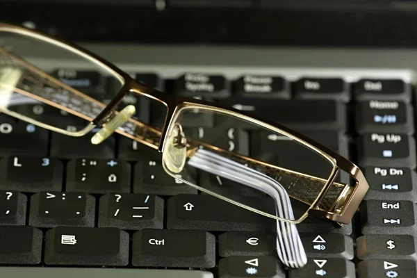 Бизнес-очки на клавиатуре ноутбука — стоковое фото