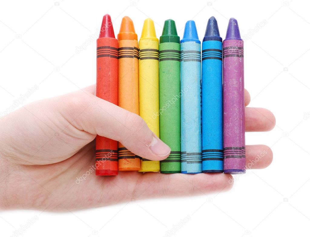 Hand holding colored crayons