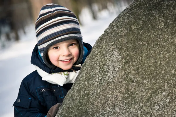 Dítě koukat z kamene — Stock fotografie